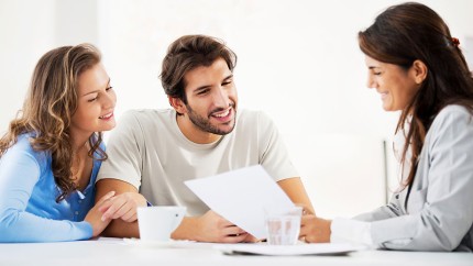 Baufinanzierung: Ehepaar lässt sich beraten und verschafft sich einen Überblick über Darlehen und Zinsen.