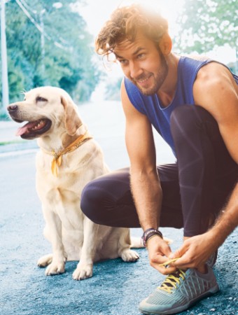 Tierhalterhaftpflicht: Mann mit Hund bereitet sich auf einen Stadtlauf vor.